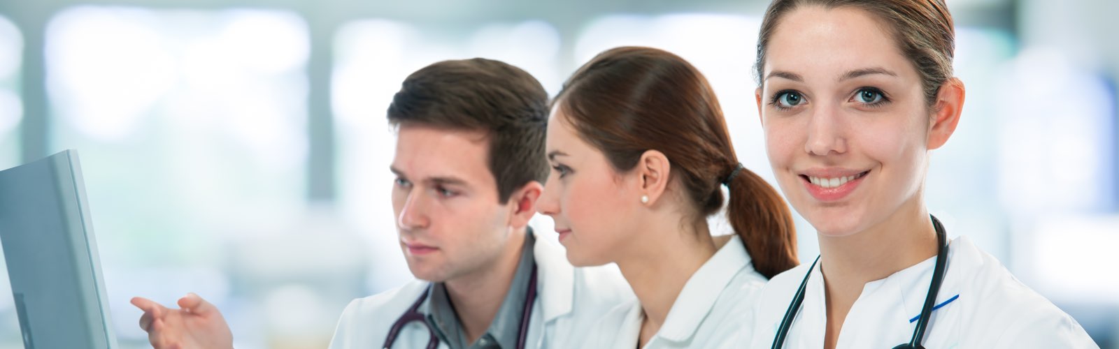 Female medical practitioner in front of team reviewing information on computer