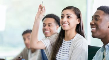 Female student in classroom raising hand