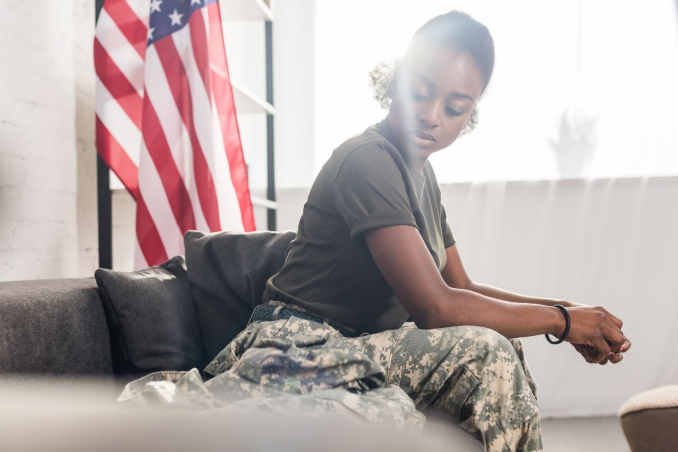 Female soldier sitting in front of American flag