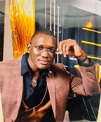 Brandon Vixamar headshot in a dark button down shirt and salmon blazer