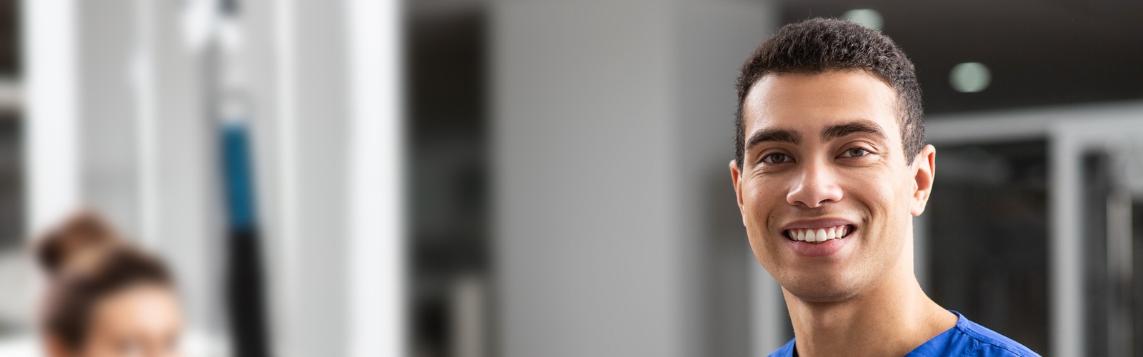 african american male healthcare worker wearing blue scrubs carrying a stack of papers