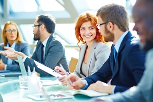 3 men and 2 women sitting at at table discussing items on their paperwork