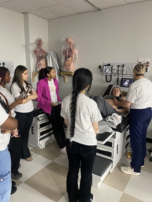 several high school student watching a nursing procedure at scrubs camp at South University