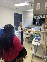 healthcare worker presenting the inner workings of a hospital room to high school students