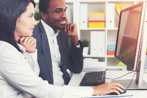 Man and woman analyzing data on computer screen