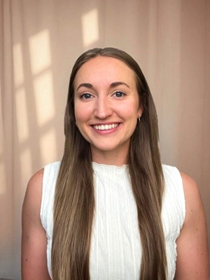 Gabrielle Giovati headshot in a white sweater blouse and long hair
