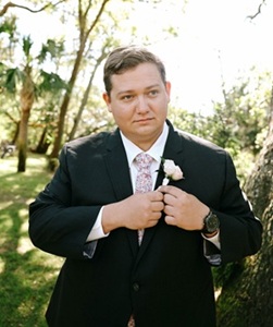Zachary Hall in wedding suit outdoors with trees behind him