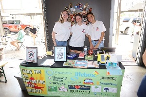 three female anesthesia science students representing South University at a booth