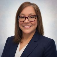 Vicki Copeland Headshot in dark blazer white blouse and glasses