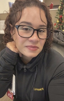 Omayra Alvarez headshot in a dark quarter zip long sleeve shirt