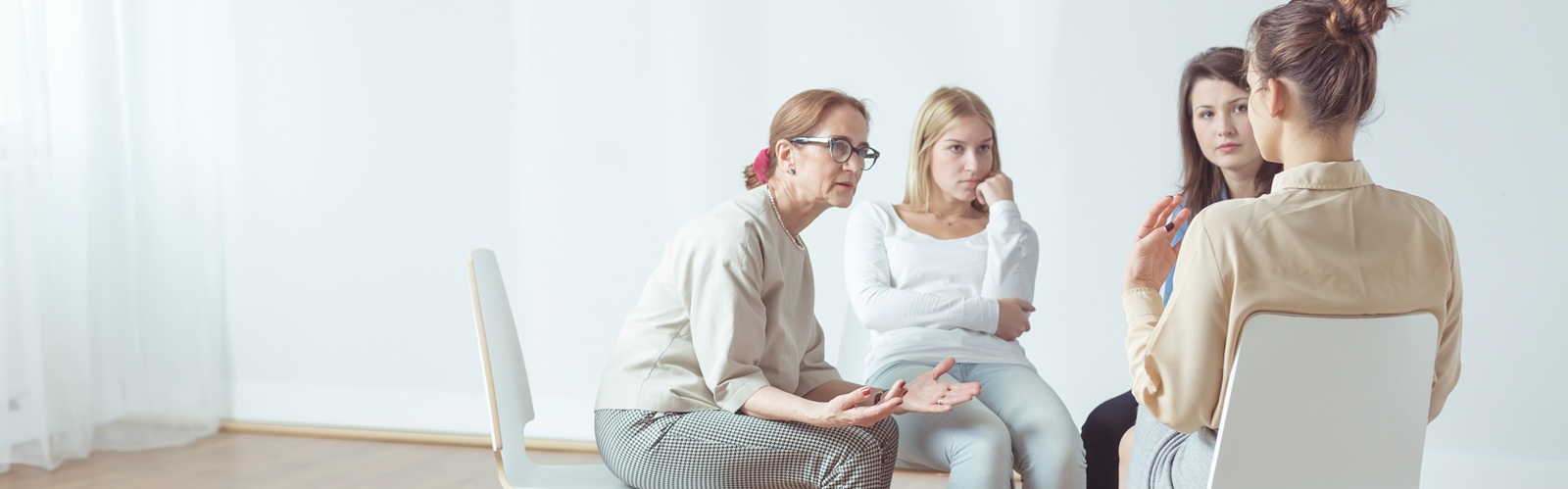 group of 4 women sitting down in a circe having a conversation