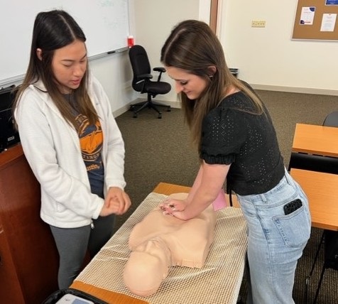 CPR demo with a nursing student and high school seniors