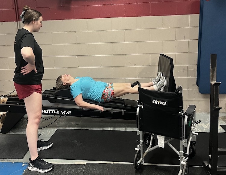 PTA student helping an older patient on a strength machine