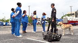 south university physician assistant students listening to a first responder with a dog in the school parking lot