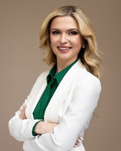 Vita Rymaruk headshot in a white coat and green blouse