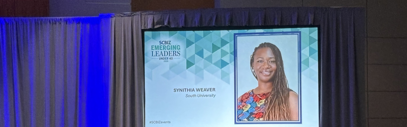 A picture of Synithia Weaver at the SCBiz event displayed for the presentation