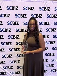 Synithia Weaver holds her trophy for her excellent work in helping veterans and military-aligned students