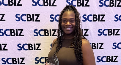 Synithia Weaver holds her award at the 2026 SCBiz event