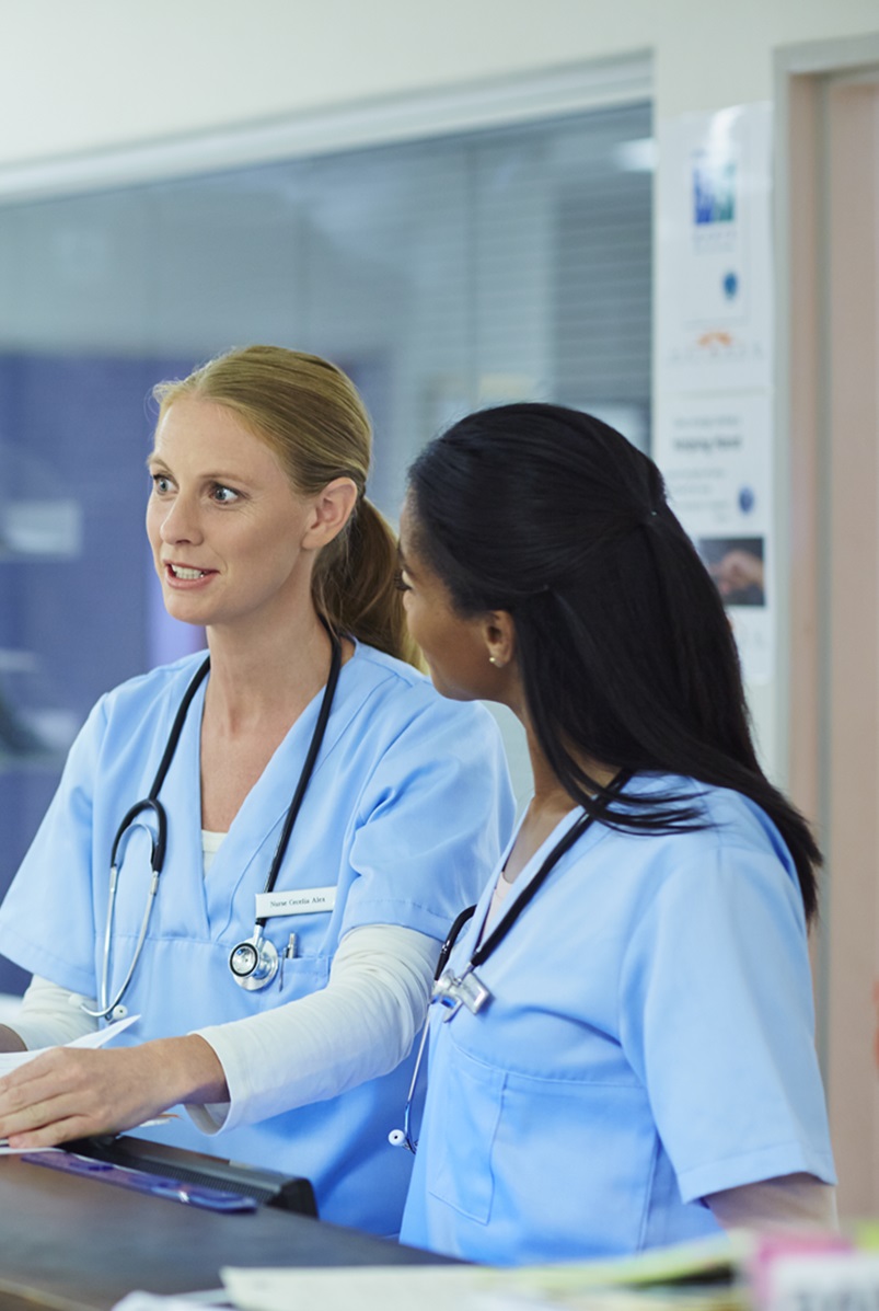 three women healthcare workers speaking in a hospital