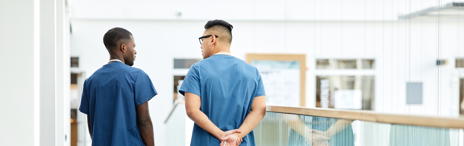 2 male healthcare workers walking down a hallway