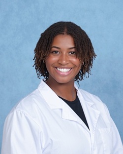 Genell O Keefe headshot in a white lab coat and dark shirt