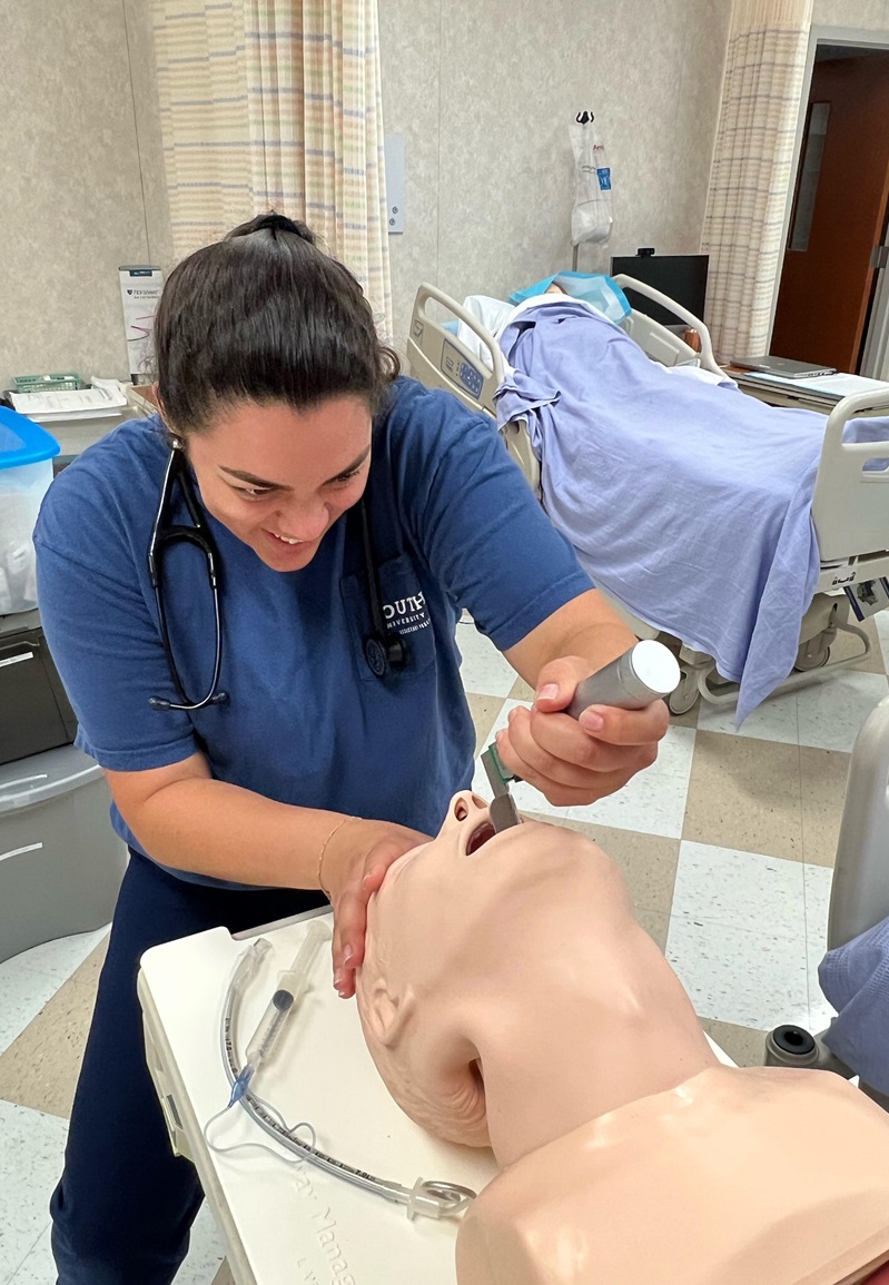 Andrea Reiter, a South University PA student, administering a procedure on a practice doll