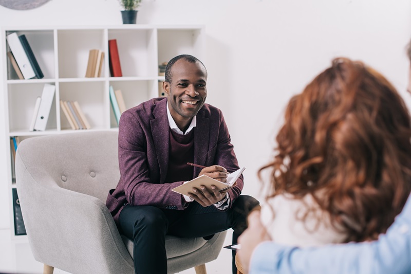 therapist in an office speaking with a female patient