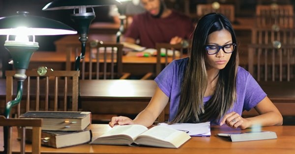 female student studying law books in a library