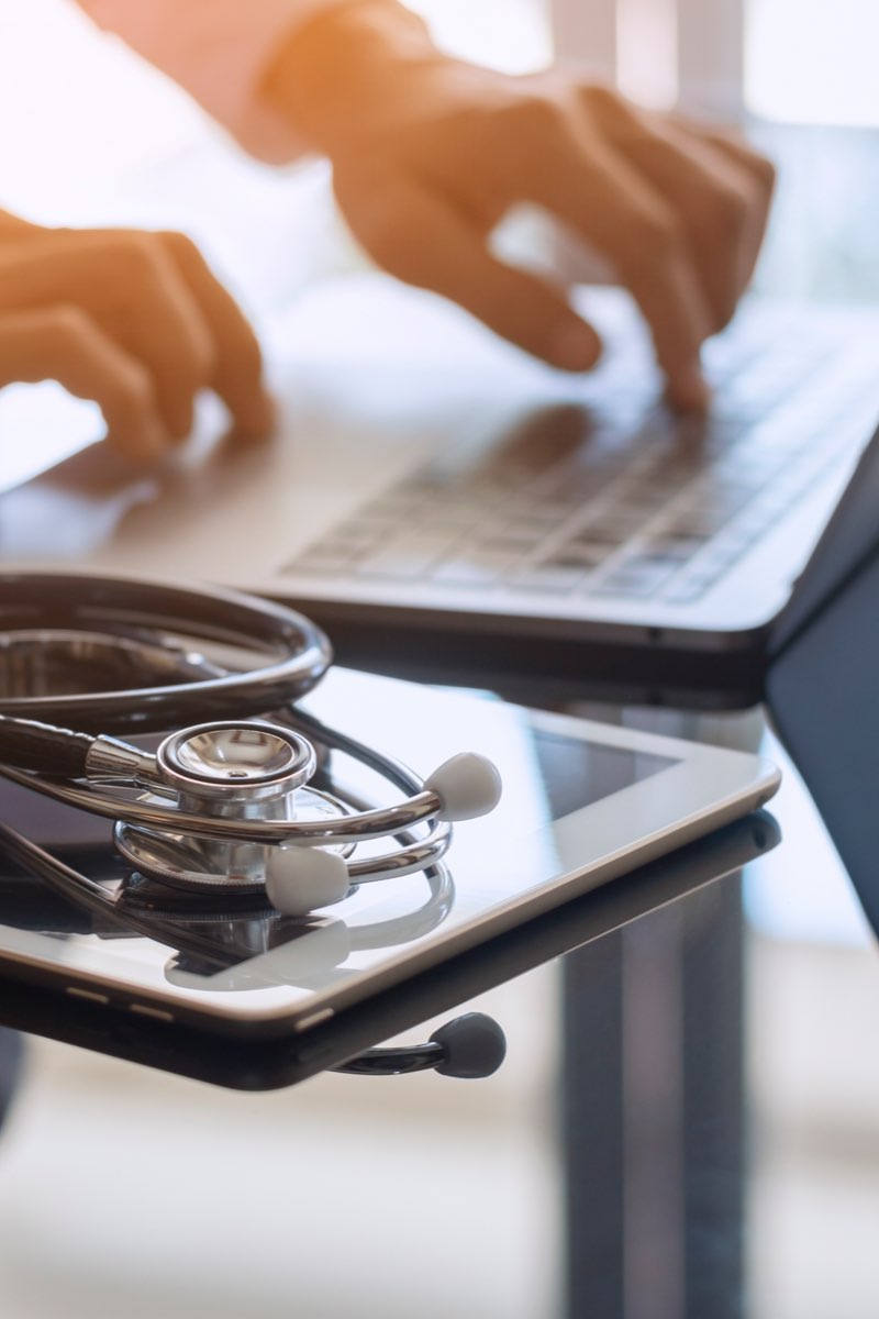 Healthcare worker typing on laptop