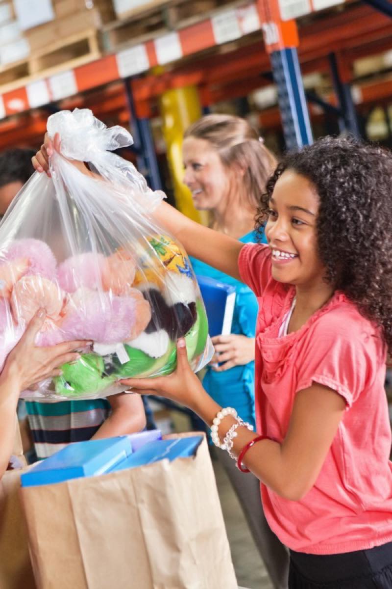 Woman handing child a basket of toys