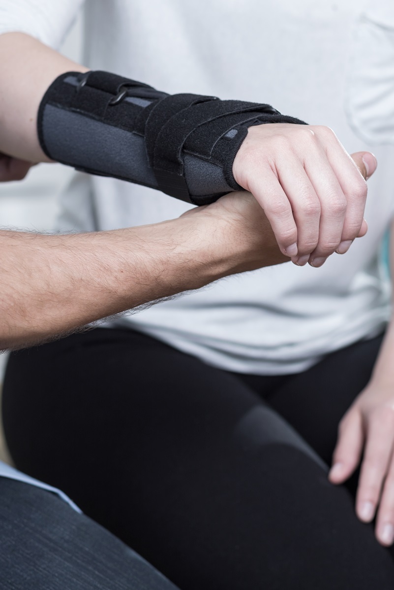 Physical Therapy Assistant assisting a patient with an arm in a cast