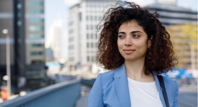 Young woman in business atire walking in city