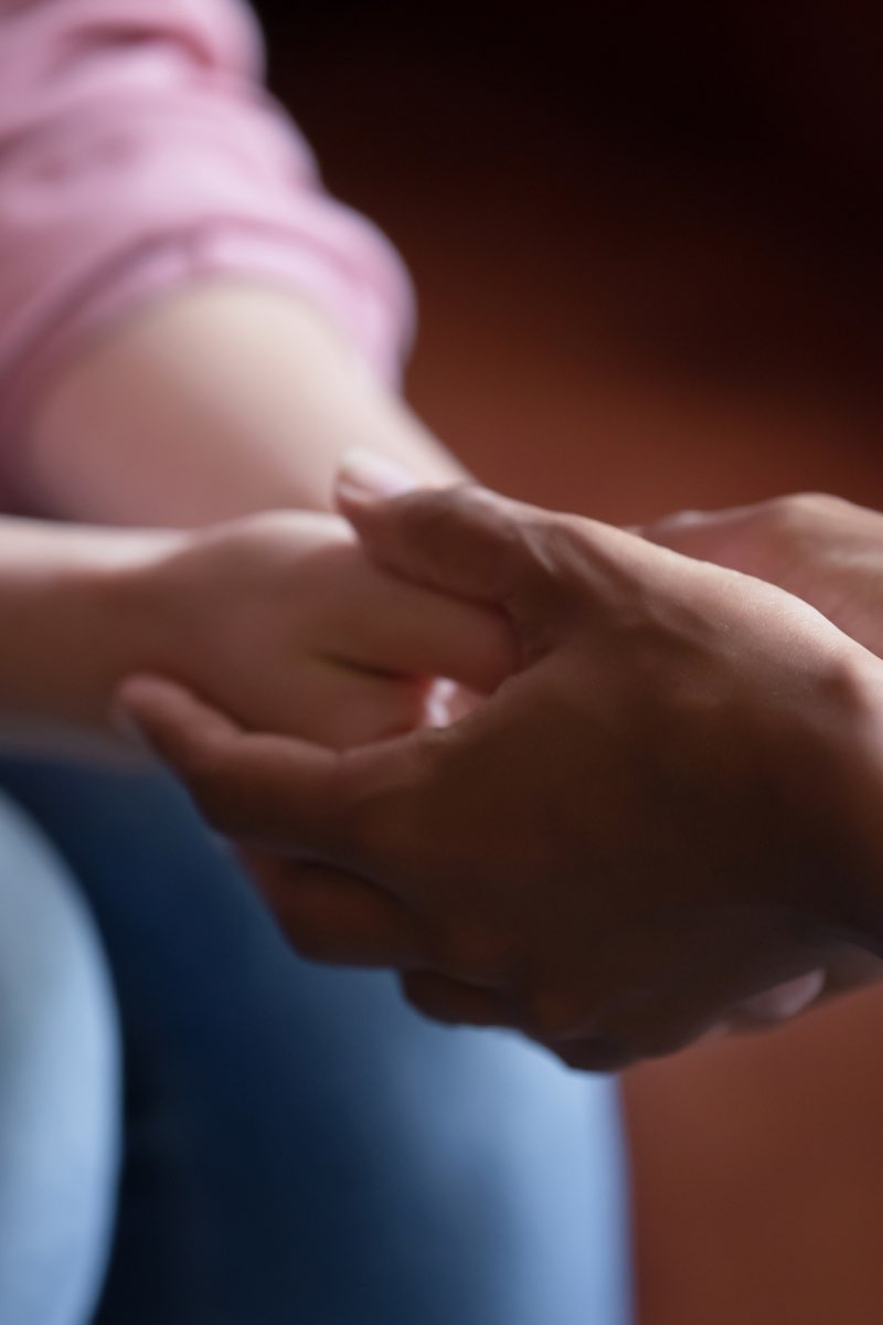 Counselor holding hands of patient