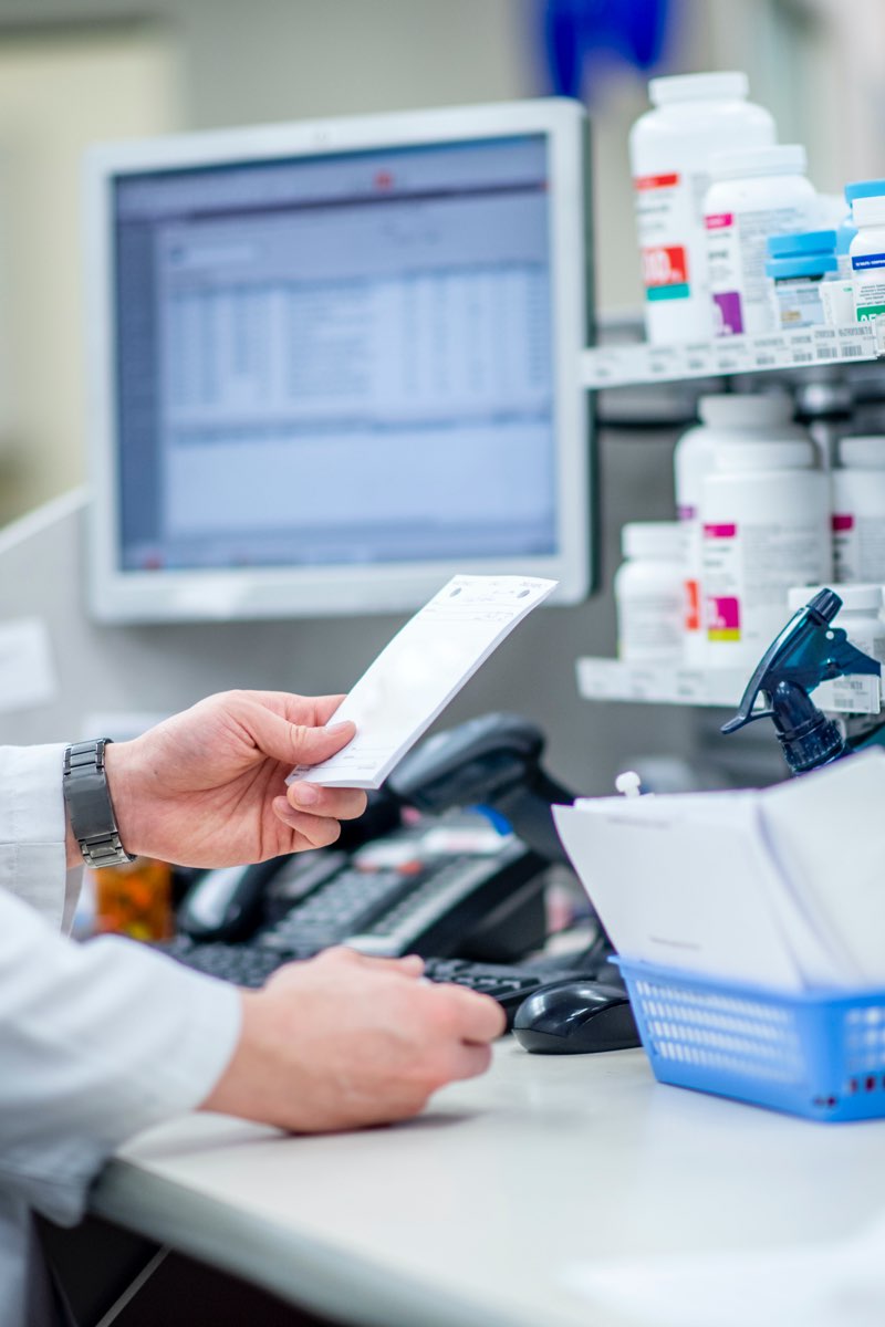Pharmacist looking at prescription in pharmacy