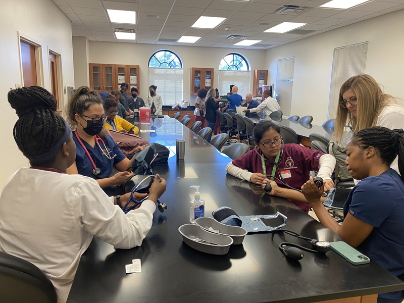 nursing students gather around a table to discuss school