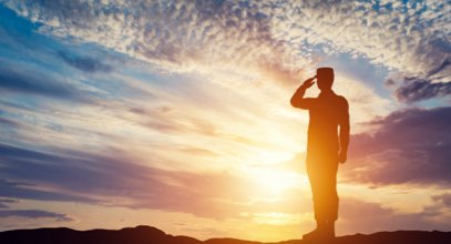 Soldier saluting at sunset