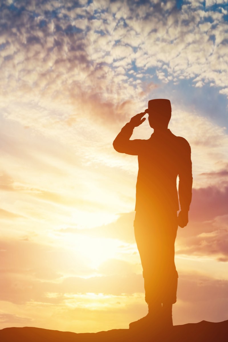 Soldier saluting at sunset