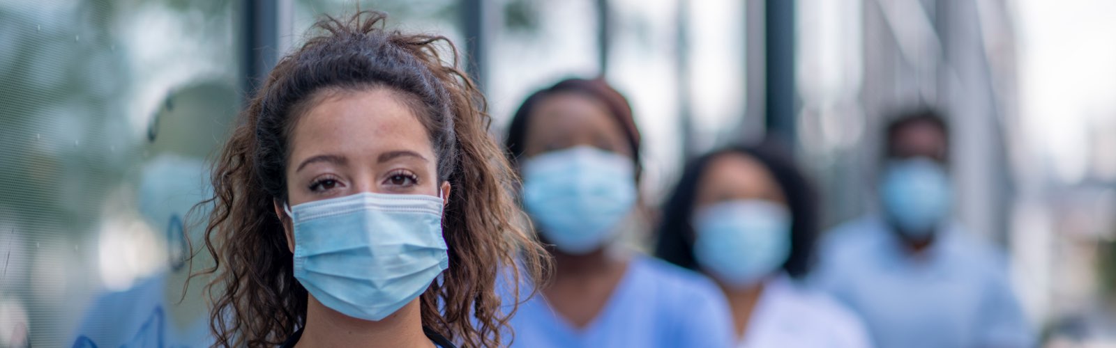 Female nurse and group of nurses wearing masks