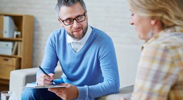 Male therapist speaking with female patient
