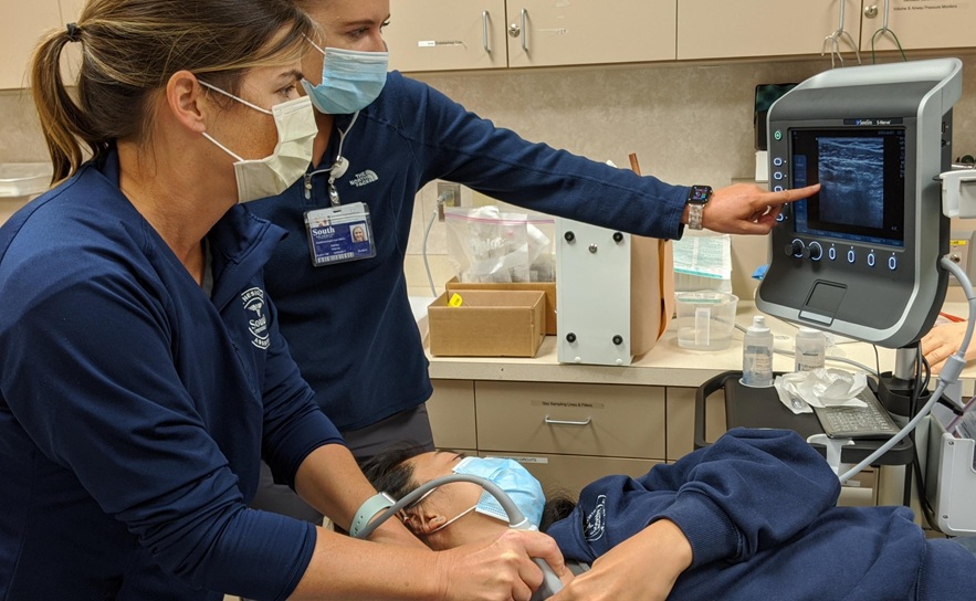three south university anesthesia assistant students practicing with an ultrasound machine