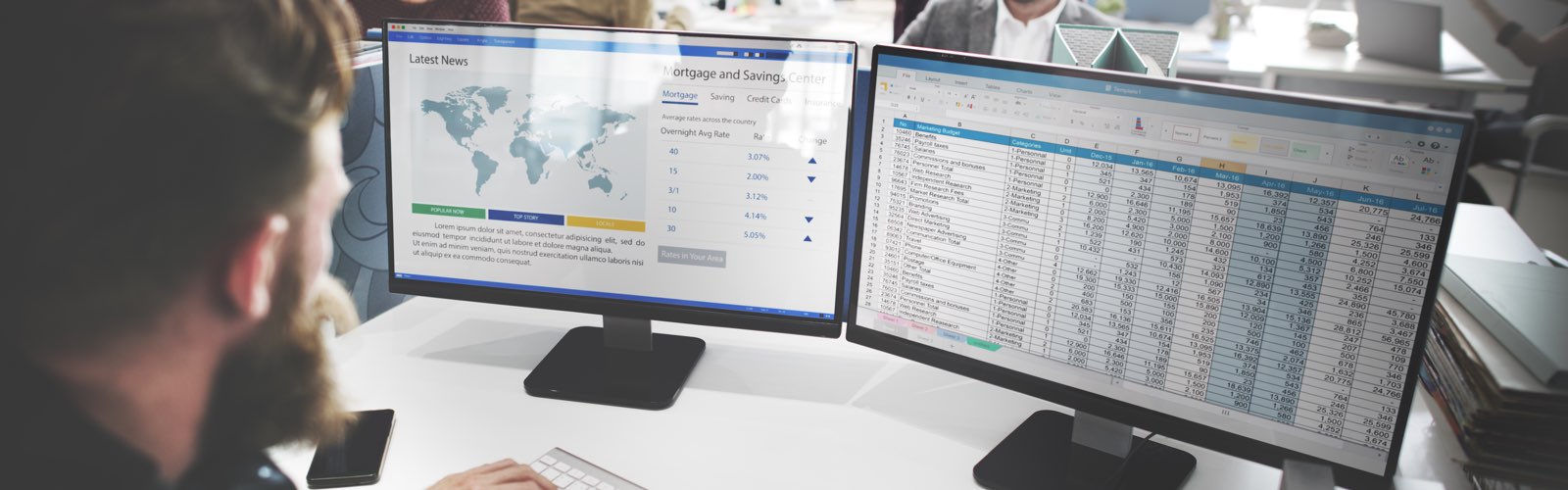 Male accountant in front of 2 computer monitors reviewing spreadsheet data