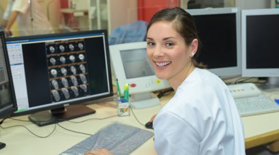 Female nurse in front of computer screen smiling