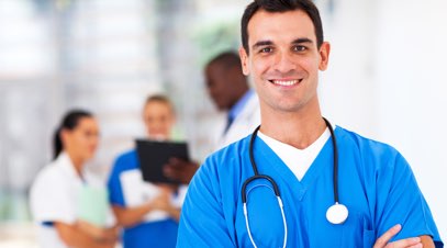 Male nurse smiling in front of team of medical professionals