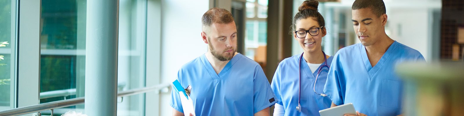 3 nurses walking through hospital talking