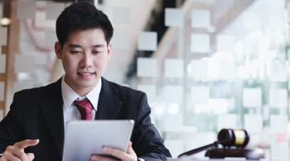 Male paralegal reviewing documents on tablet