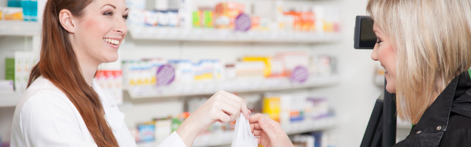 Female pharmacist handing prescription to patient