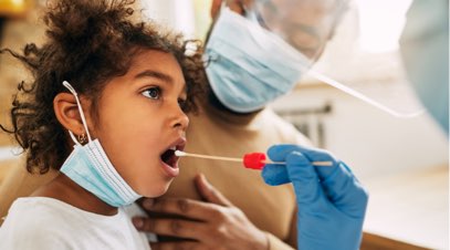 Healthcare professional swabbing child's mouth as parent watches