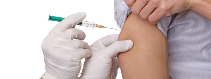 Nurse giving a vaccination in upper arm