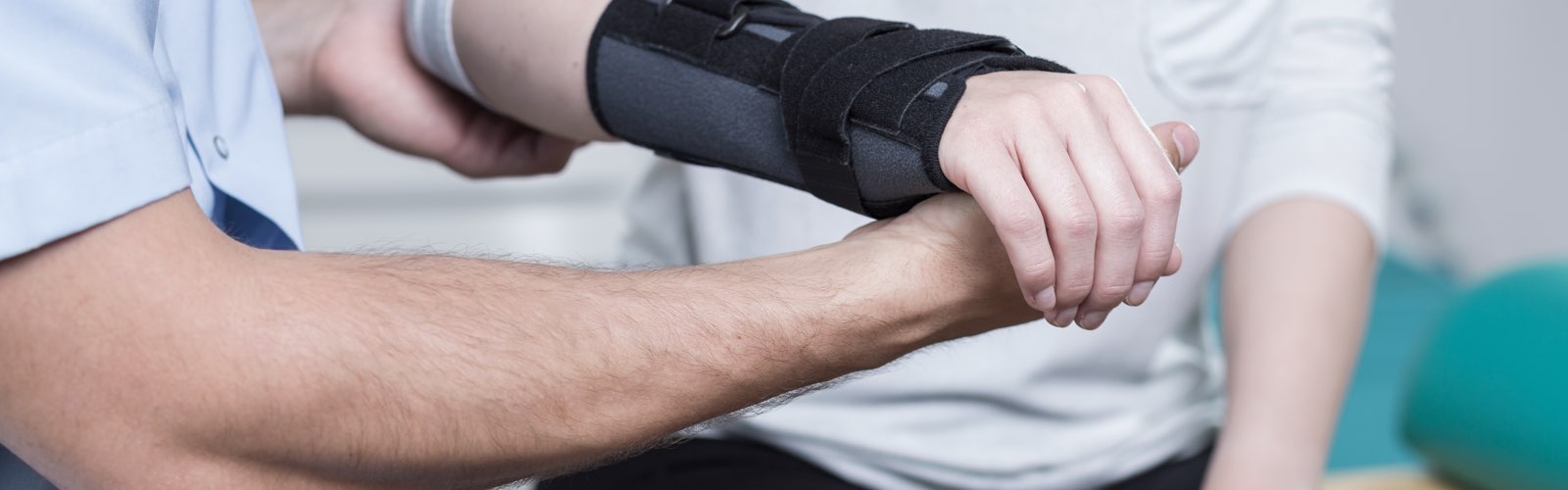 Physical therapist holding patient's arm in cast
