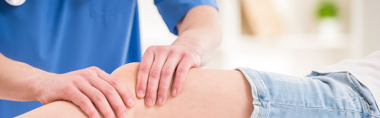 Physical therapist massaging patient's knee